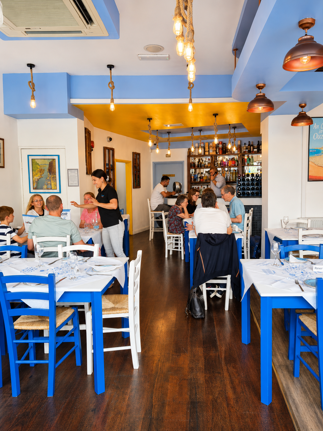 The bright dining room at Island with white tables and blue chairs