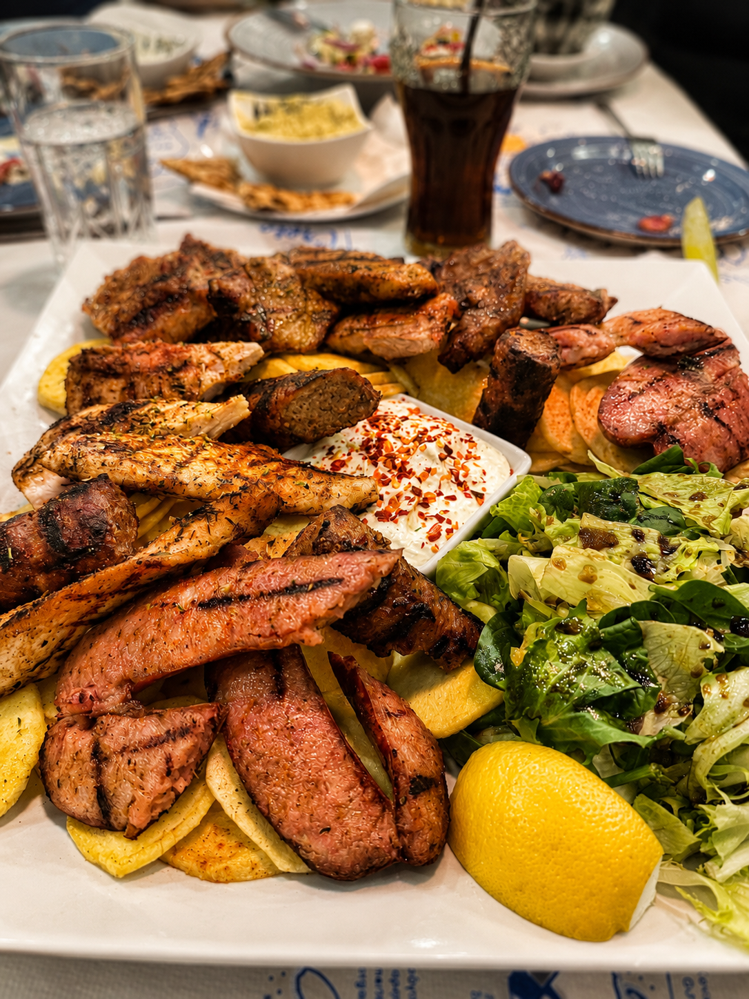 A generous mixed grill platter with salad, chips and tzatziki